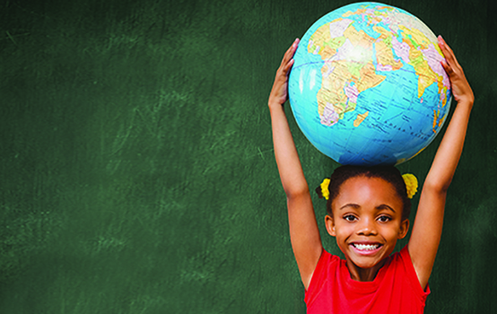 Pupil holding globe against green chalkboard